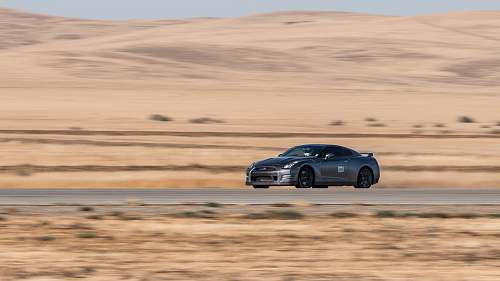 sports car Nissan GTR passing through road on desert desert